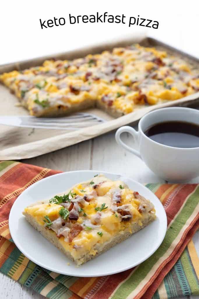 Titled image of a slice of keto breakfast pizza on a white plate with a cup of coffee and the rest of the pizza in the background.