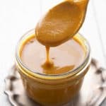 Titled image of a jar of keto Carolina Gold BBQ Sauce with a spoon lifting some out of the jar.