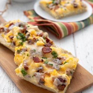 Three slices of keto breakfast pizza on a wooden cutting board.