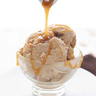 Keto caramel sauce being drizzled over a bowl of keto salted caramel ice cream.