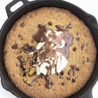 Top down image of a keto skillet cookie topped with ice cream and chocolate sauce.