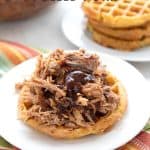 Titled image of keto pulled pork served on a waffle bun, on a white plate.