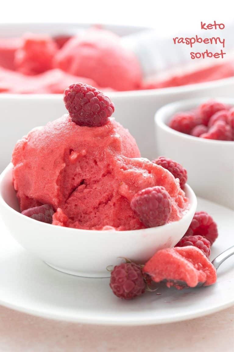 Titled image of a bowl of sugar free raspberry sorbet in a white bowl with a spoonful taken out.