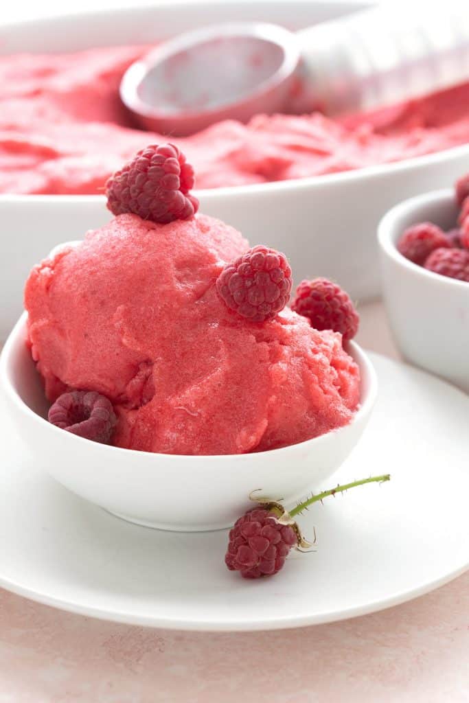A bowl of sugar free sorbet with raspberries on top.