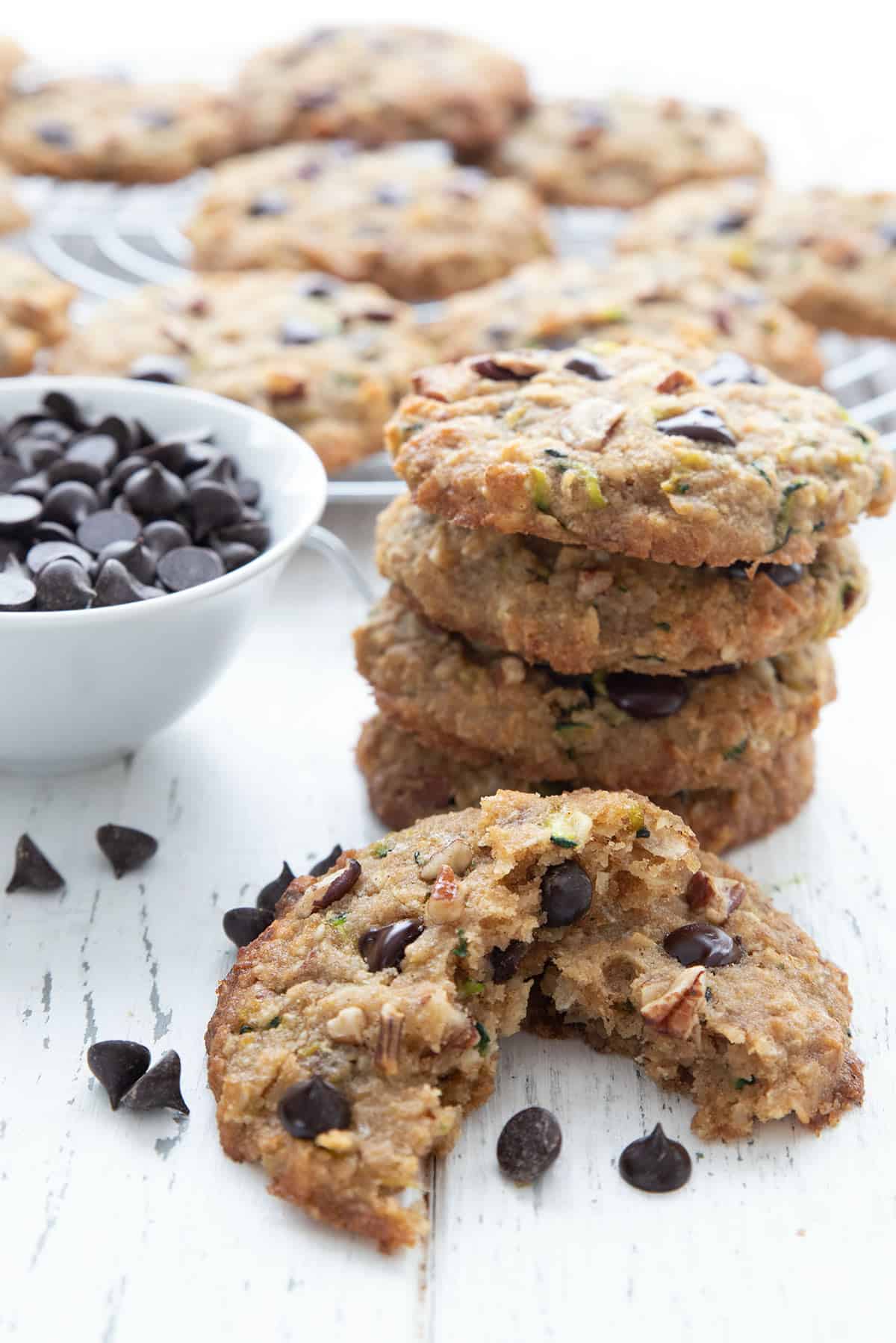 A stack of zucchini cookies with one in front, broken open.