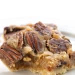 Close up shot of a keto pecan pie bar with a bite taken out of it.