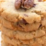 Titled image close up of a stack of keto butter pecan cookies on a white plate.