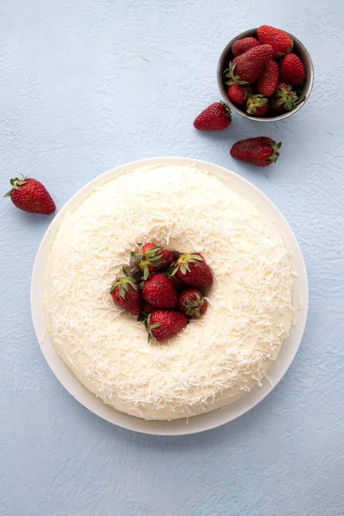 Top down image of keto coconut bundt cake with strawberries in the center.