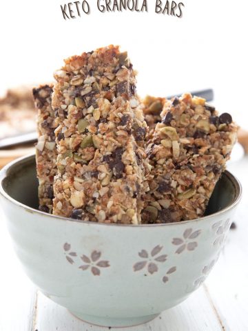 Titled image of keto granola bars standing up in a light green bowl.