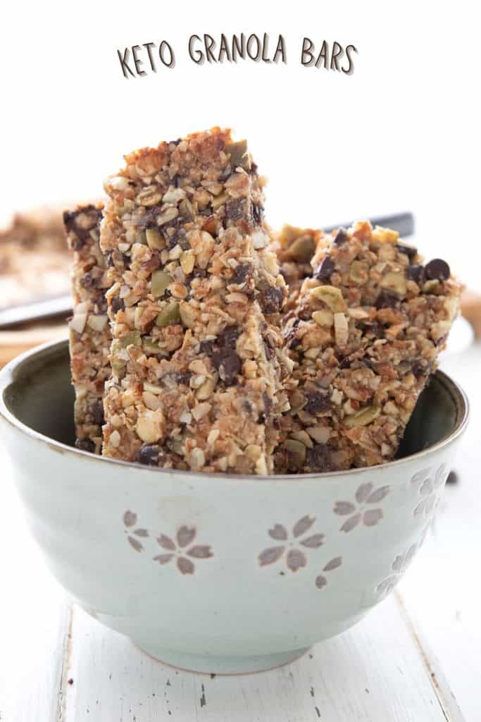 Titled image of keto granola bars standing up in a light green bowl.