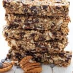 Titled image of a stack of keto granola bars with pecans and chocolate chips in front.