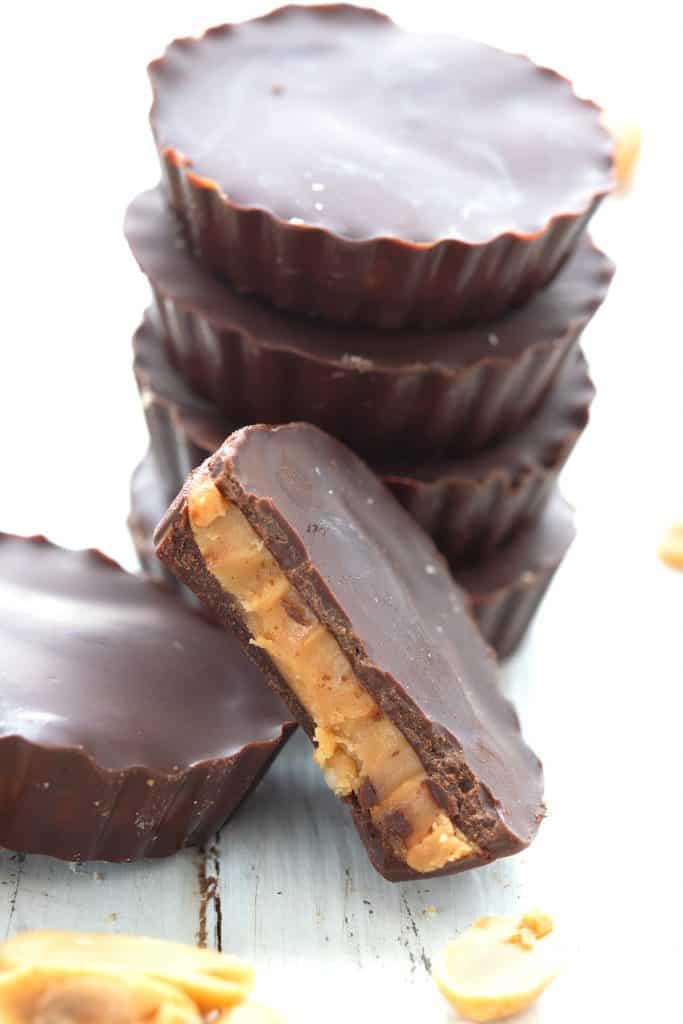 Close up shot of a stack of keto peanut butter cups, and the front one has a bite taken out of it.
