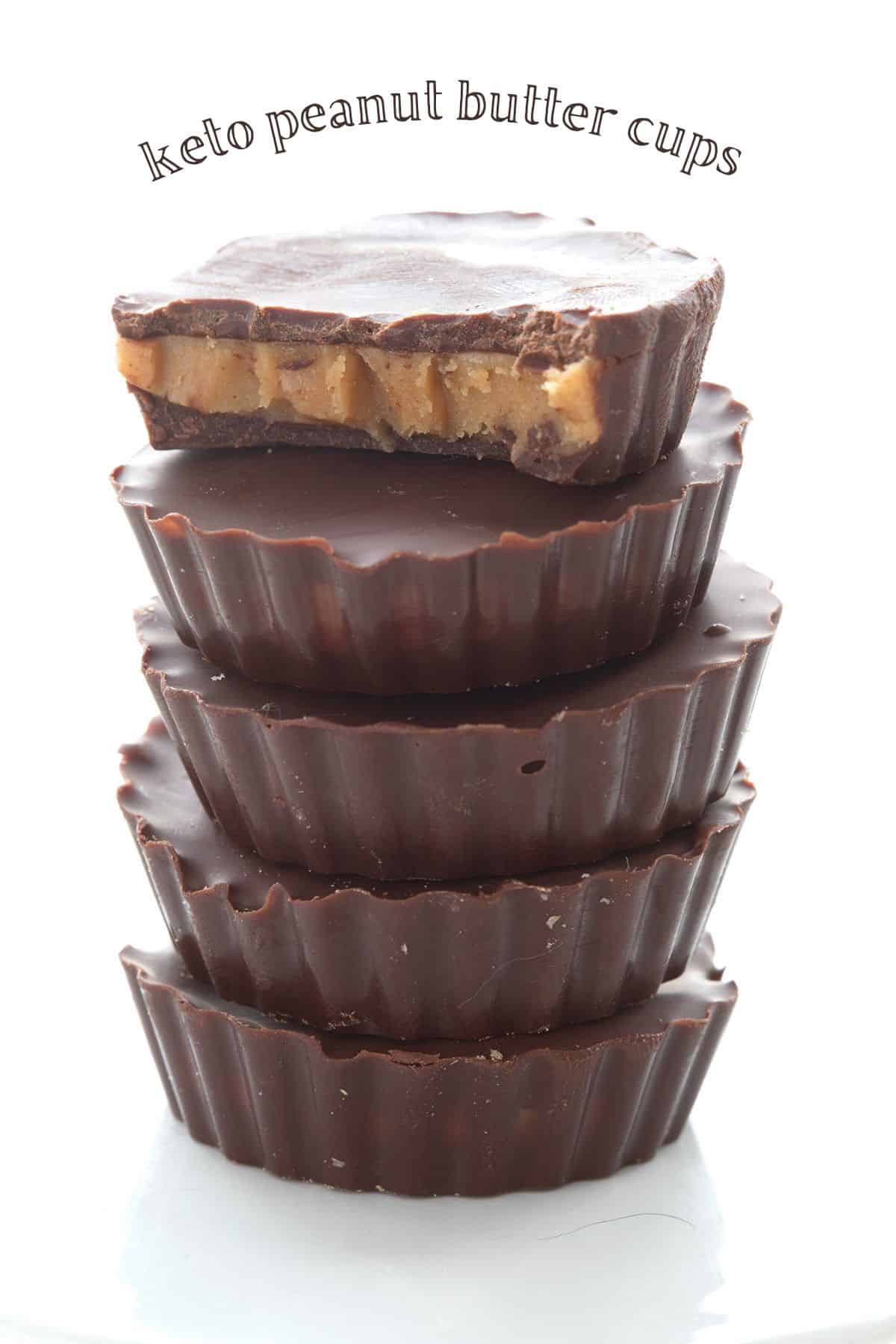 Titled image of a stack of keto peanut butter cups, and the top one has a bite taken out of it.