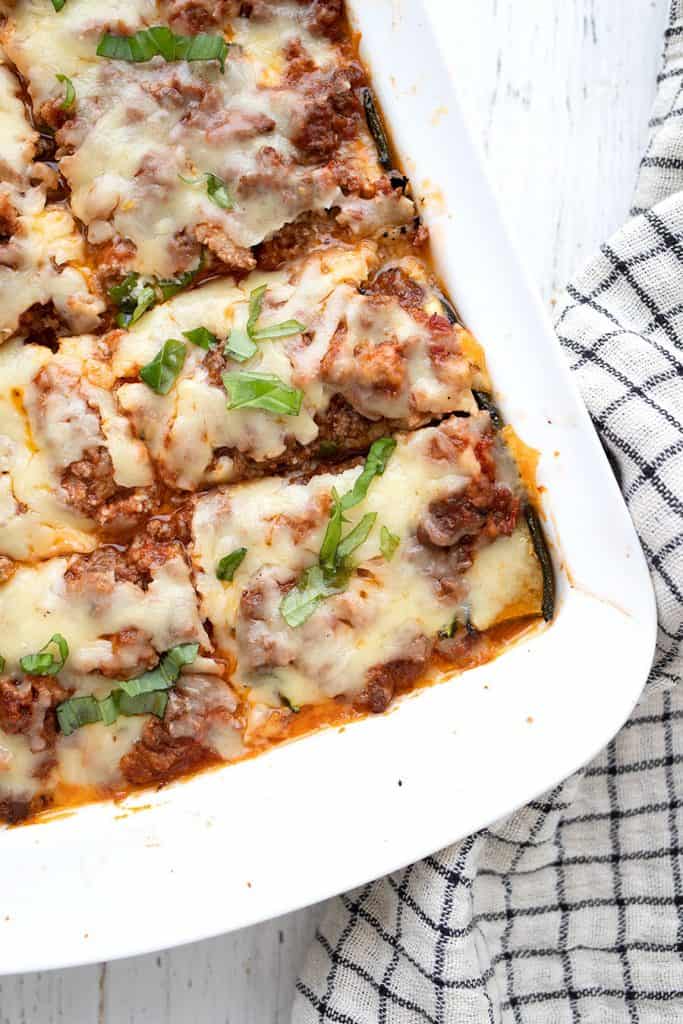 Top down image of zucchini lasagna in a white baking pan.
