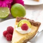 Titled Pinterest image of a slice of keto key lime pie on a white plate with raspberries.