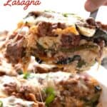 A hand pulling out a slice of keto zucchini lasagna from a white dish with more lasagna in it