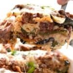 Titled image of a piece of Grilled Zucchini Lasagna being lifted out of a white baking dish.