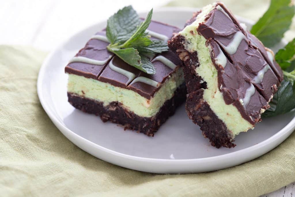 Close up shot of keto mint chocolate bars on a white plate over a green napkin.