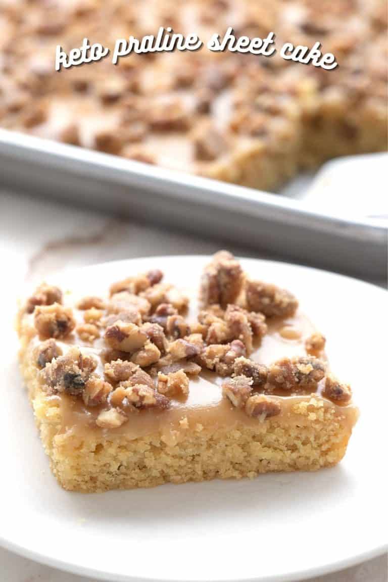 A slice of keto pecan praline sheet cake on a white plate, with the tray of cake in the background.