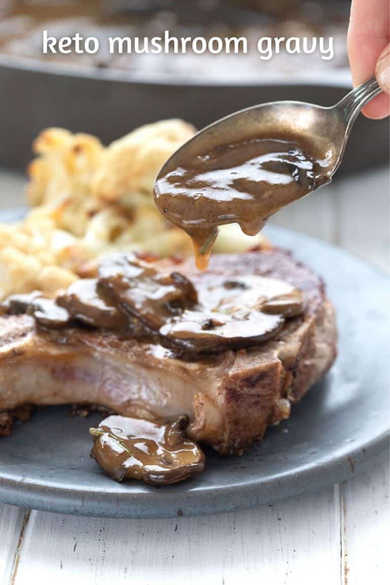 A spoon drizzling keto mushroom gravy over pork chops.