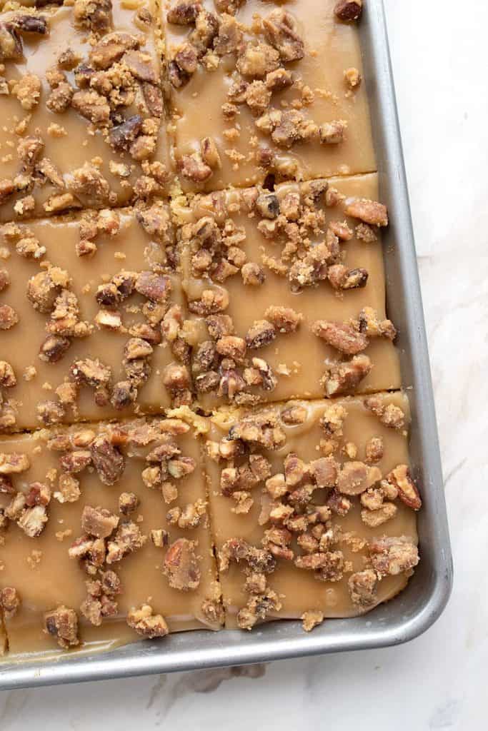 Top down photo of keto praline sheet cake in the pan, cut into slices.