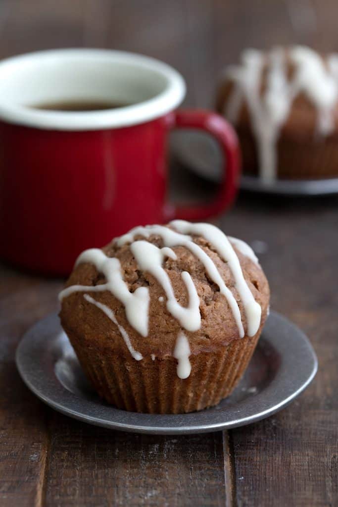 Närbild av en keto pepparkaksmuffin med en kopp kaffe i bakgrunden.