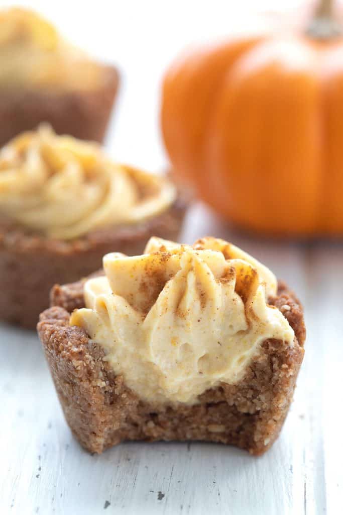 Close up shot of a keto pumpkin cheesecake bite with a bite taken out of it.