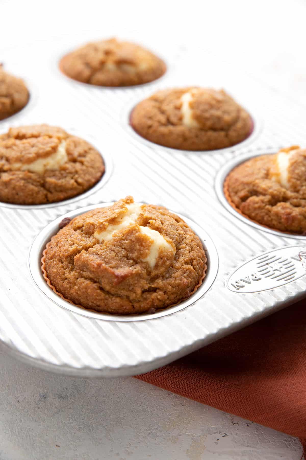 A pan of keto pumpkin muffins filled with cream cheese. 