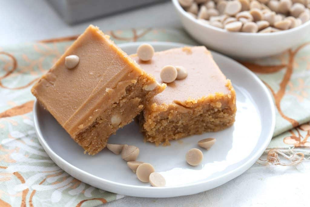Close up shot of two keto triple peanut butter blondies on a white plate.