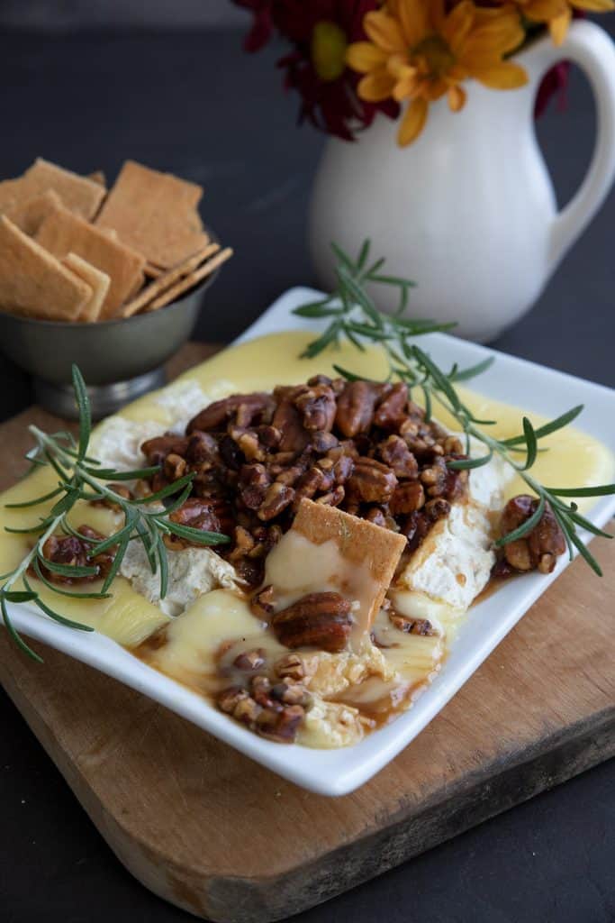 A plate of baked brie with caramel pecans and a bowl of keto crackers.