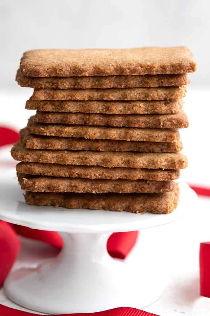A stack of thin, crispy keto speculoos cookies on a small cake stand.