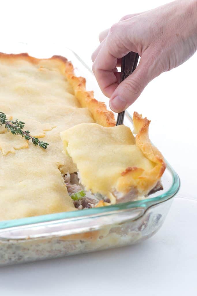 A hand scooping out a serving of keto turkey pot pie.