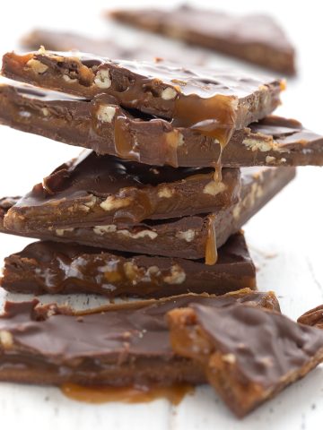 A stack of keto pecan turtle bark with chewy sugar free caramel oozing out.
