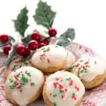 Titled image: Keto Ricotta Cookies on a red patterned plate with holly in the background.