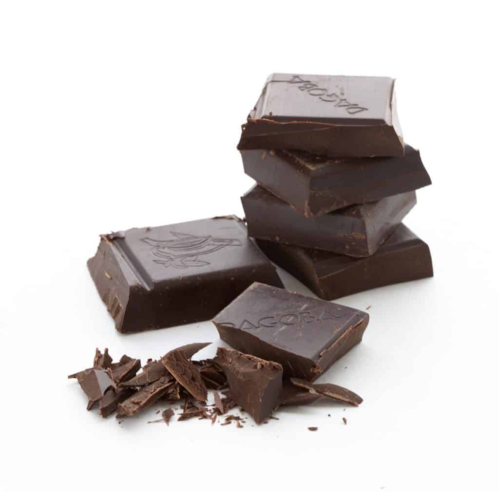 Unsweetened chocolate stacked up on a white background