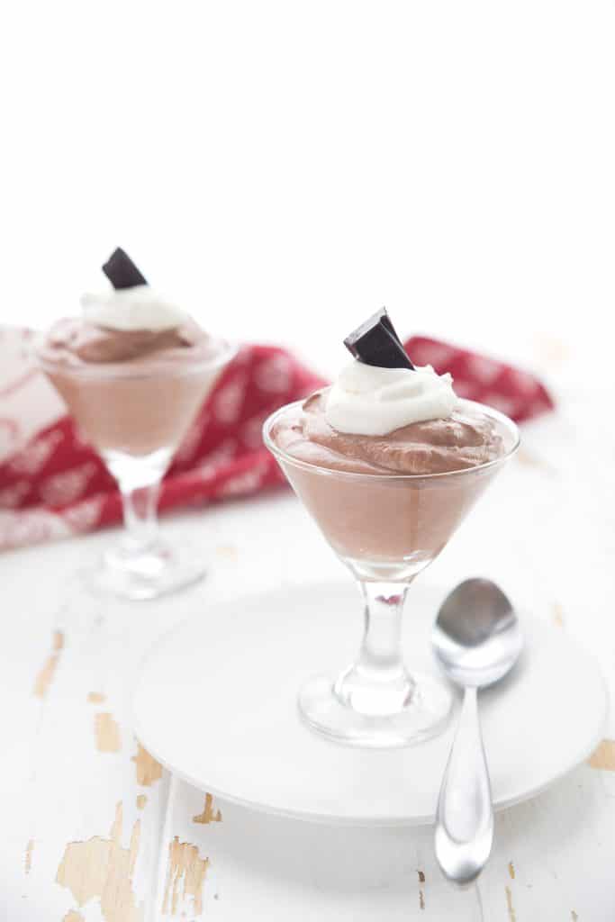 Two dessert glasses full of easy keto cheesecake mousse on a white table.