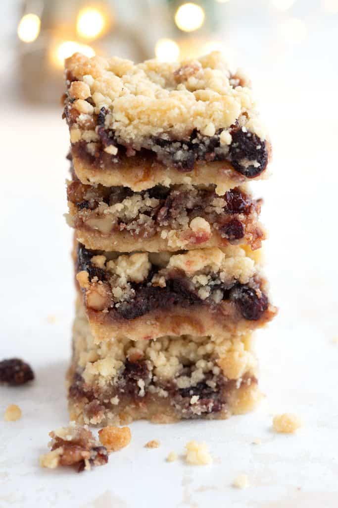 A stack of keto mincemeat shortbread bars on a white background with Christmas lights.