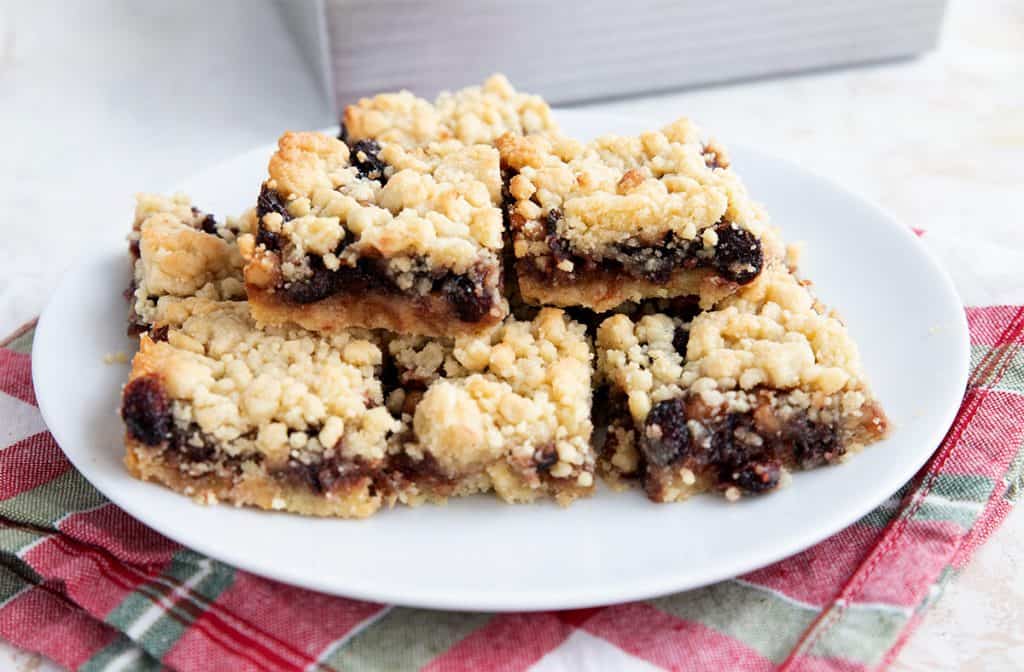 Keto mincemeat bars stacked on a white plate over a red and green patterned napkin