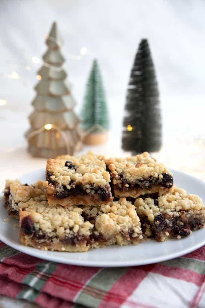 Keto mincemeat bars on a white plate with holiday decorations in the background.