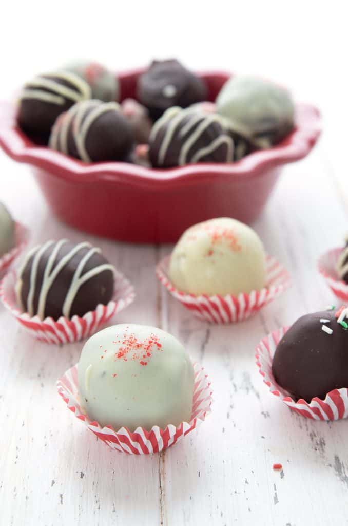 Keto truffles dipped in white and dark sugar-free dark chocolate, in red and white striped candy cups.