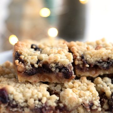 Close up shot of keto mincemeat shortbread bars on a white plate with Christmas lights in the background.