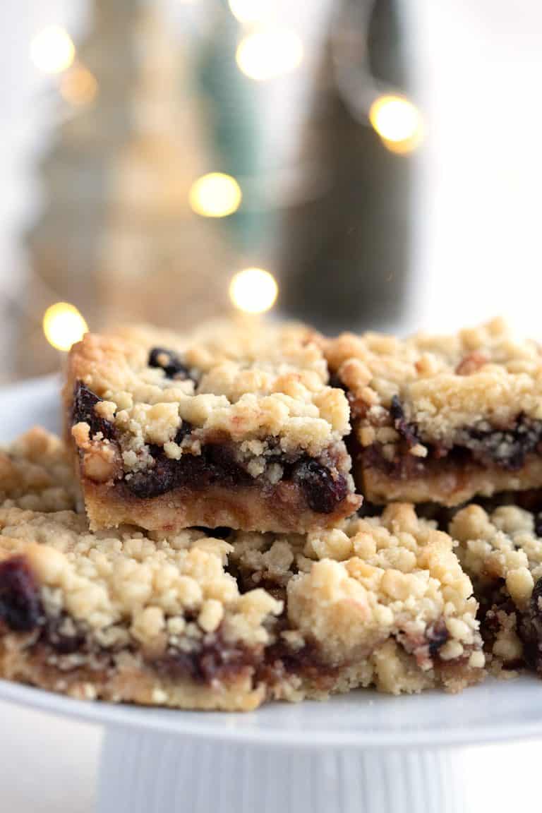 Close up shot of keto mincemeat shortbread bars on a white plate with Christmas lights in the background.