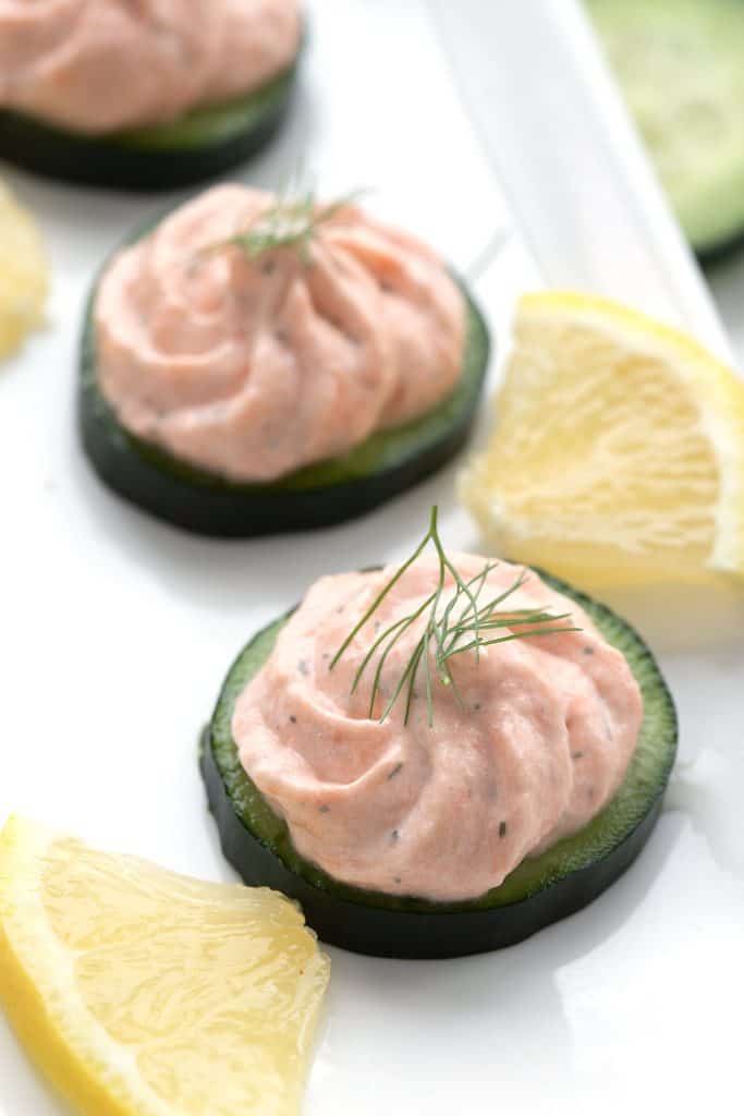 Close up shot of smoked salmon mousse on slices of cucumber.