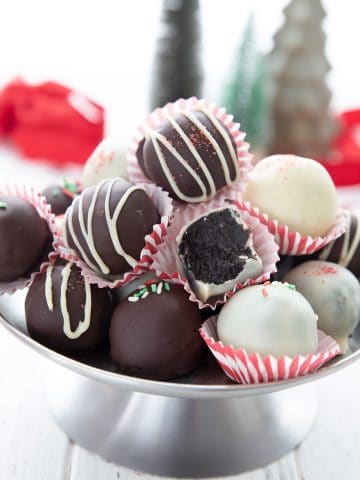 Keto peppermint oreo truffles piled up on a metal cake stand.