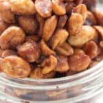 Close up shot of keto toffee peanuts in a glass jar.