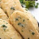 Titled pinterest image of keto breadsticks lined up on a black tray.