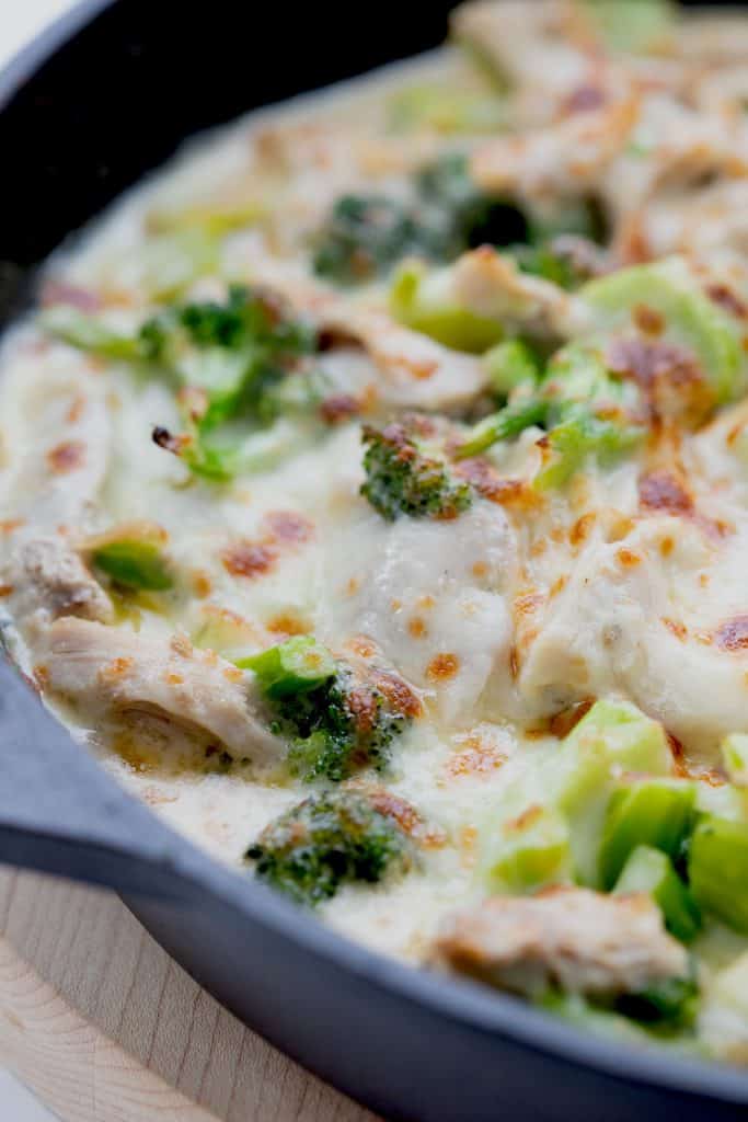 Close up shot of keto chicken broccoli casserole in a cast iron skillet.