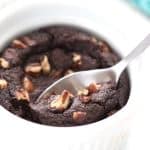 Close up shot of a keto mug brownie with a spoon digging into it.