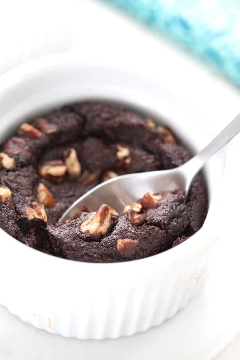 Close up shot of a keto mug brownie with a spoon digging into it.