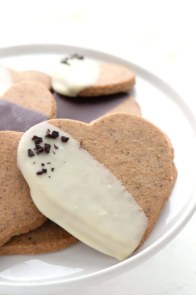 Close up shot of chocolate dipped keto shortbread on a white cake platter.